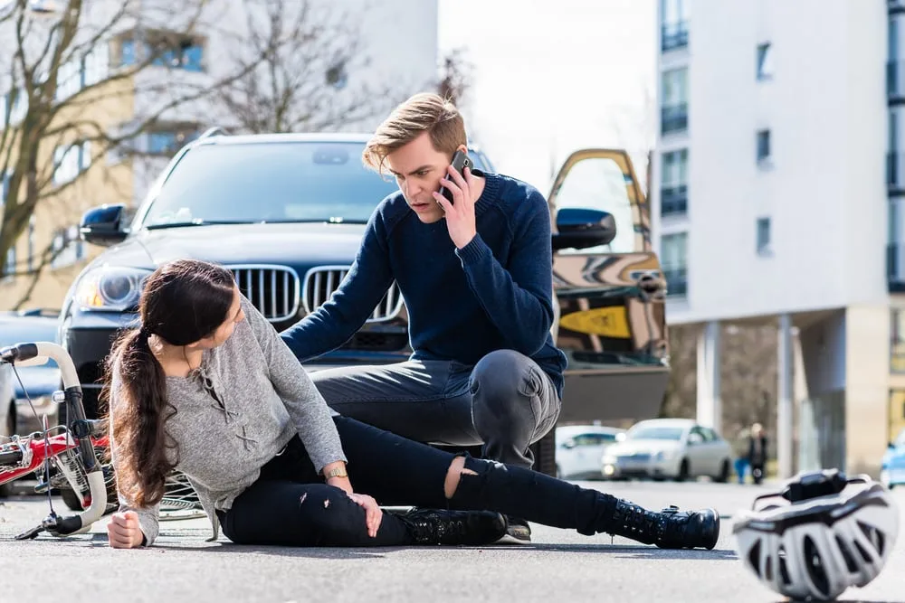 Person calling EMS while checking on the injured person