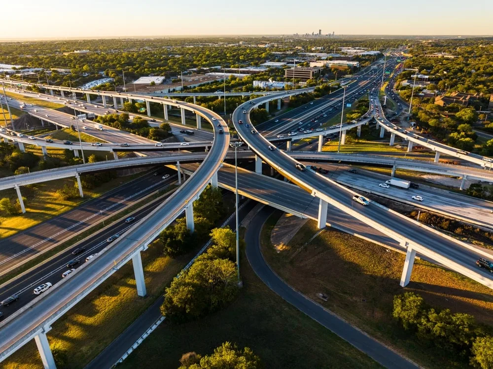 A symetrical turnaround interchange. Elevated Transportation Highway aerial drone sunrise over busy road way in Austin, Texas, USA