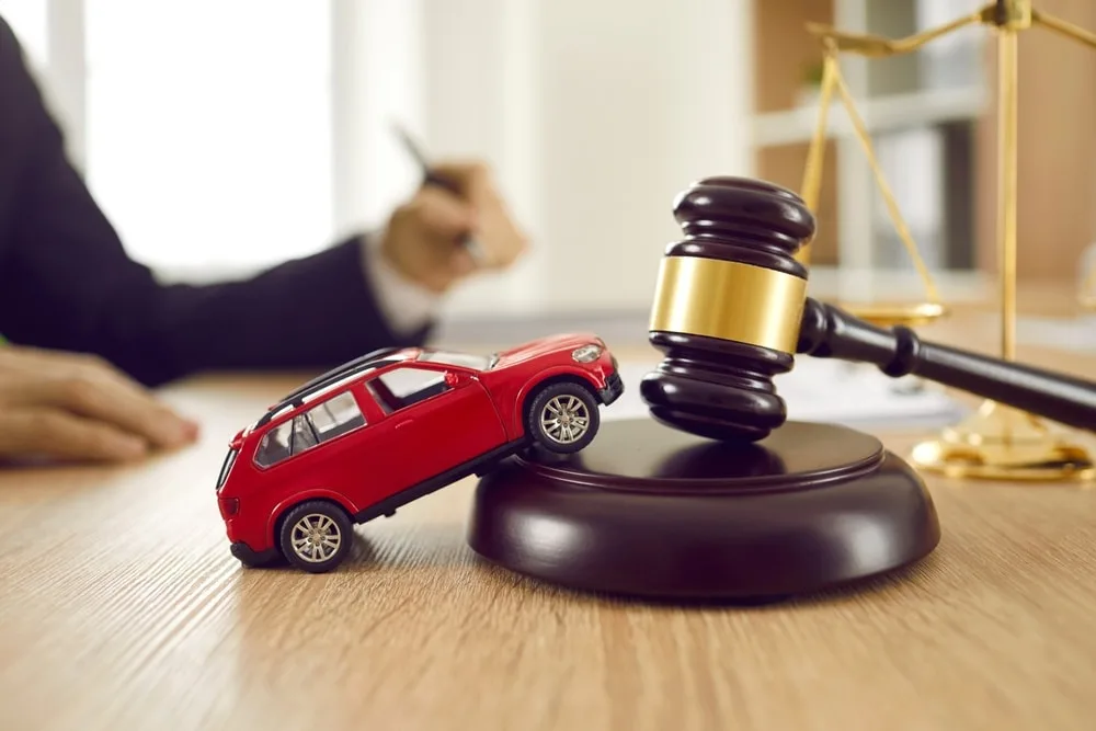 Closeup of a toy car and gavel on a table