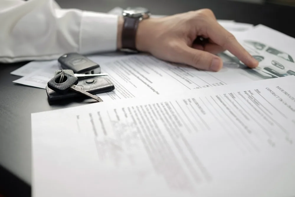 Auto accident lawyer overlooking documents with car keys beside him
