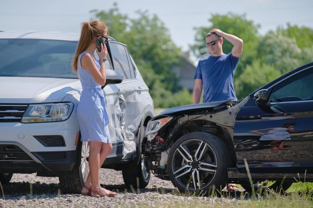 Two drivers inspecting their cars after a t-bone car accident